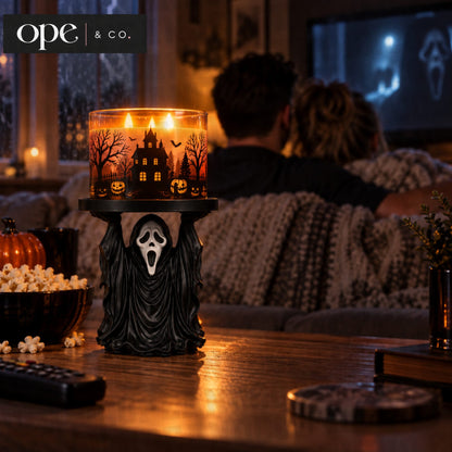 Ghost candle holder stand holding a lit three-wick candle during movie night